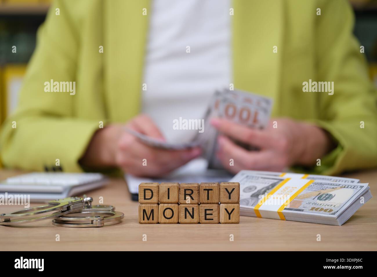 Untersuchung der Folgen von finanziellem Fehlverhalten, umgeben von Bargeld und Andeutungen rechtlicher Schwierigkeiten Stockfoto