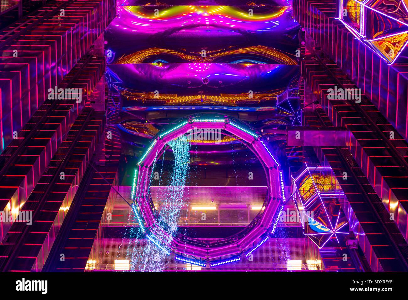 Eine immersive Kunstinstallation bietet lila und pinkfarbene Neonlichter, geometrische Formen und reflektierende Oberflächen. Moderne Kunst, Lichtinstallation, Interac Stockfoto