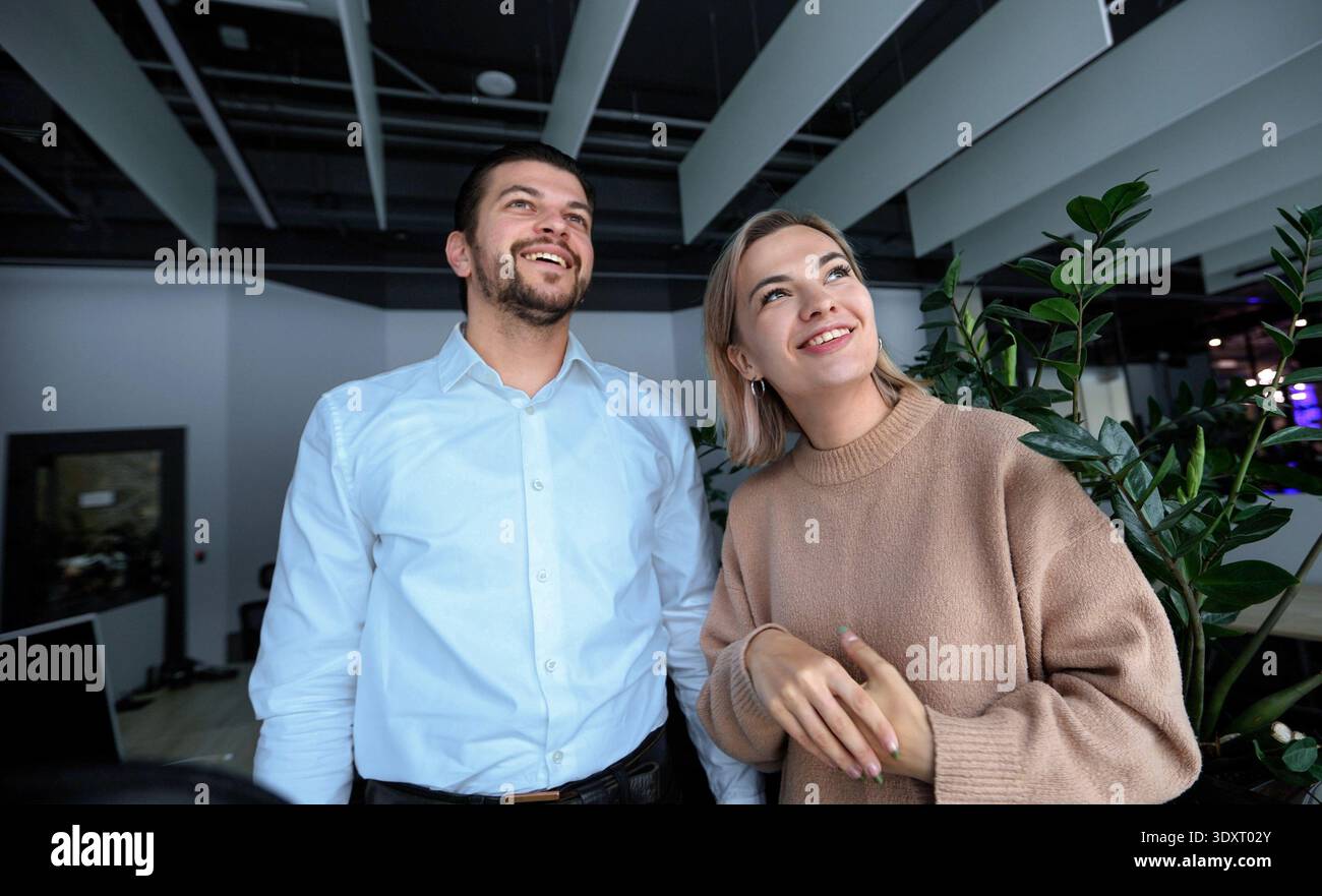 Ein Mann und eine Frau stehen vor einer Pflanze Stockfoto