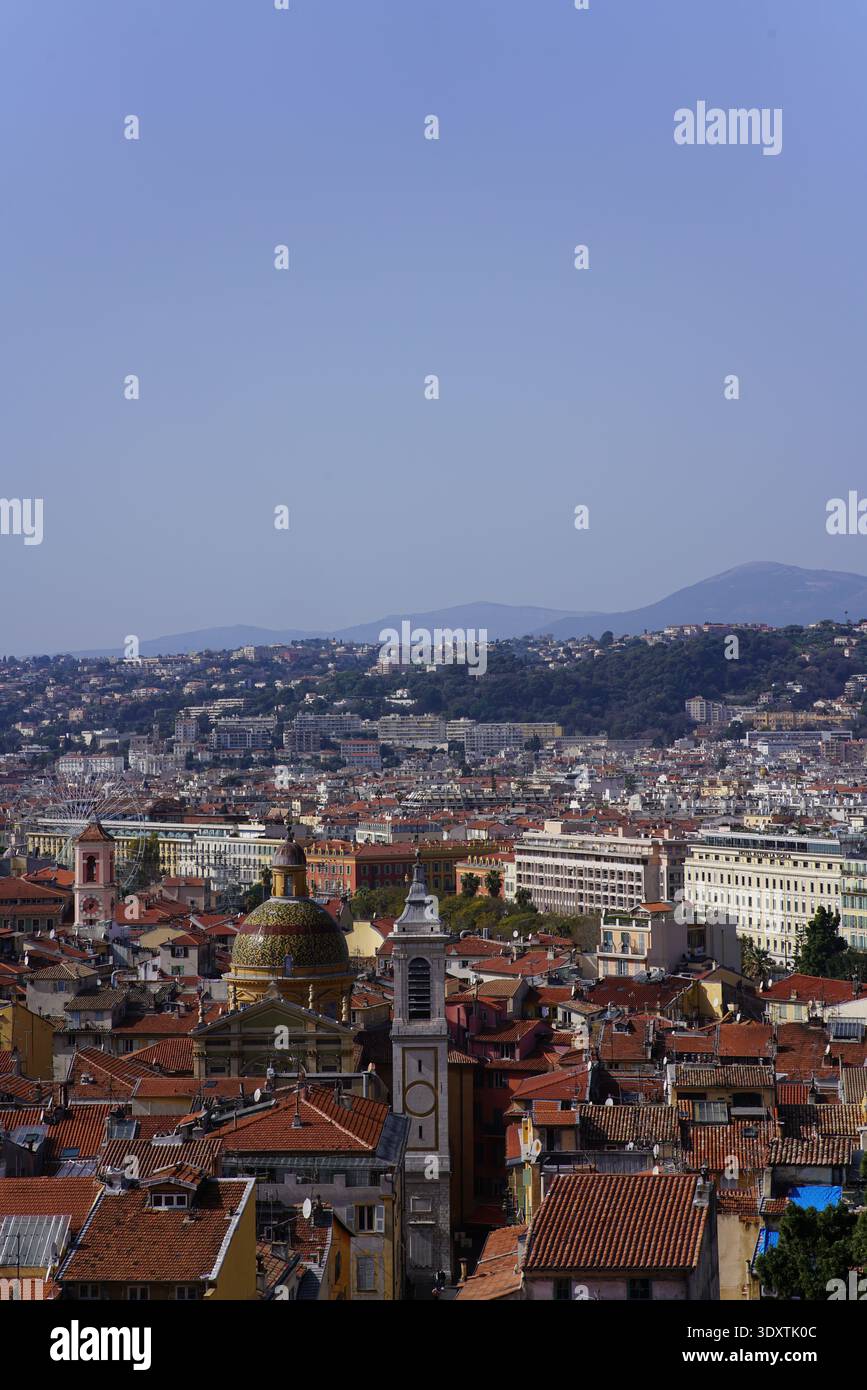 Panoramablick über die Dächer der Altstadt von Nizza mit Kuppeln, Glockenturm und Terrakottafliesen unter klarem Himmel vom Hügel aus. Nizza, Frankreich Stockfoto