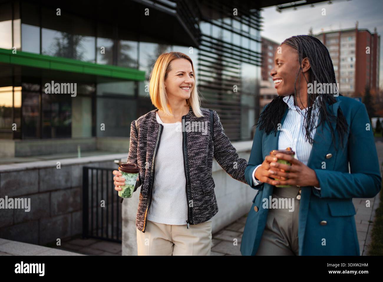 Verschiedene Geschäftspartner laufen und unterhalten sich während der Kaffeepause Stockfoto