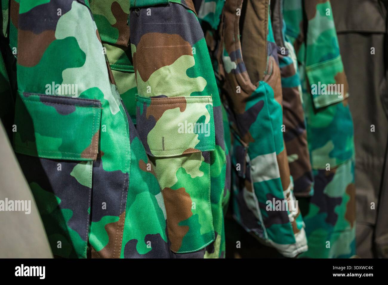 Tarnung von grünen und braunen Militäruniformen in einem Lagerhaus Stockfoto