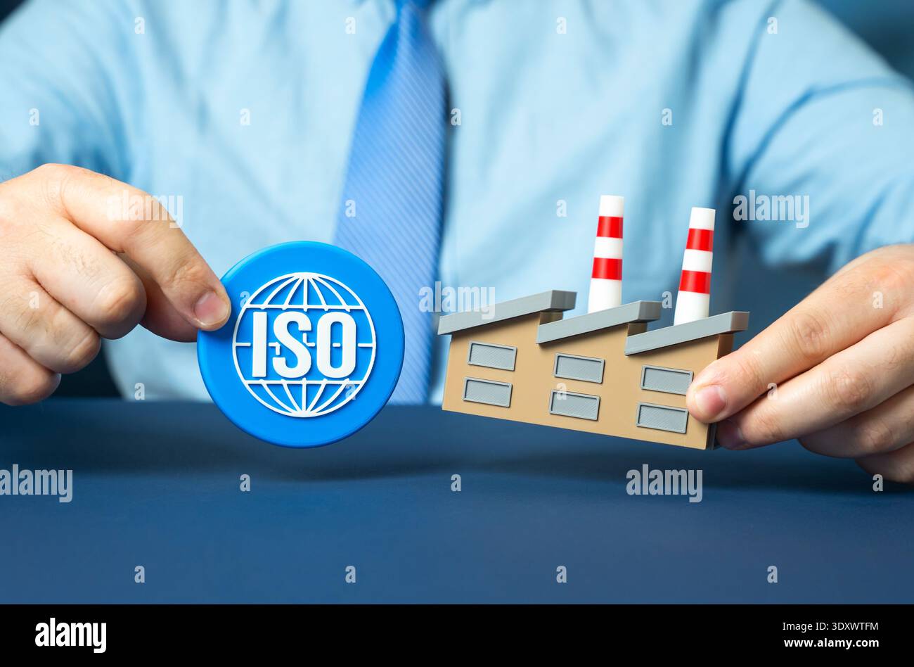 Ein Beamter hält ein ISO-Symbol in der Nähe einer Industrieanlage. Produkt- und Produktionsstandardisierung für Zertifizierung, Exportzugriff und Compliance mit i Stockfoto