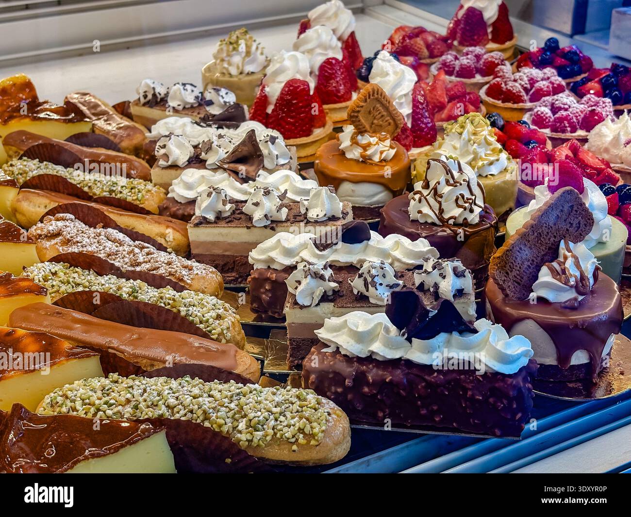 Patisserie Window in Nizza, Frankreich, mit luxuriösem französischem Gebäck, frischen Obsttörtchen, Schokoladenéclairs und cremigen Desserts. Stockfoto