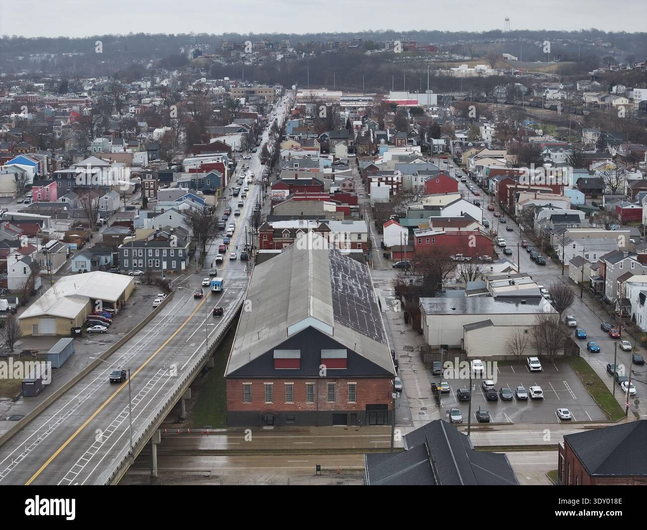 Aus der Vogelperspektive eines Ziegelgebäudes, eingebettet zwischen Straßen und Strukturen unter gedämpftem Himmel, Newport, Kentucky, USA. Stockfoto