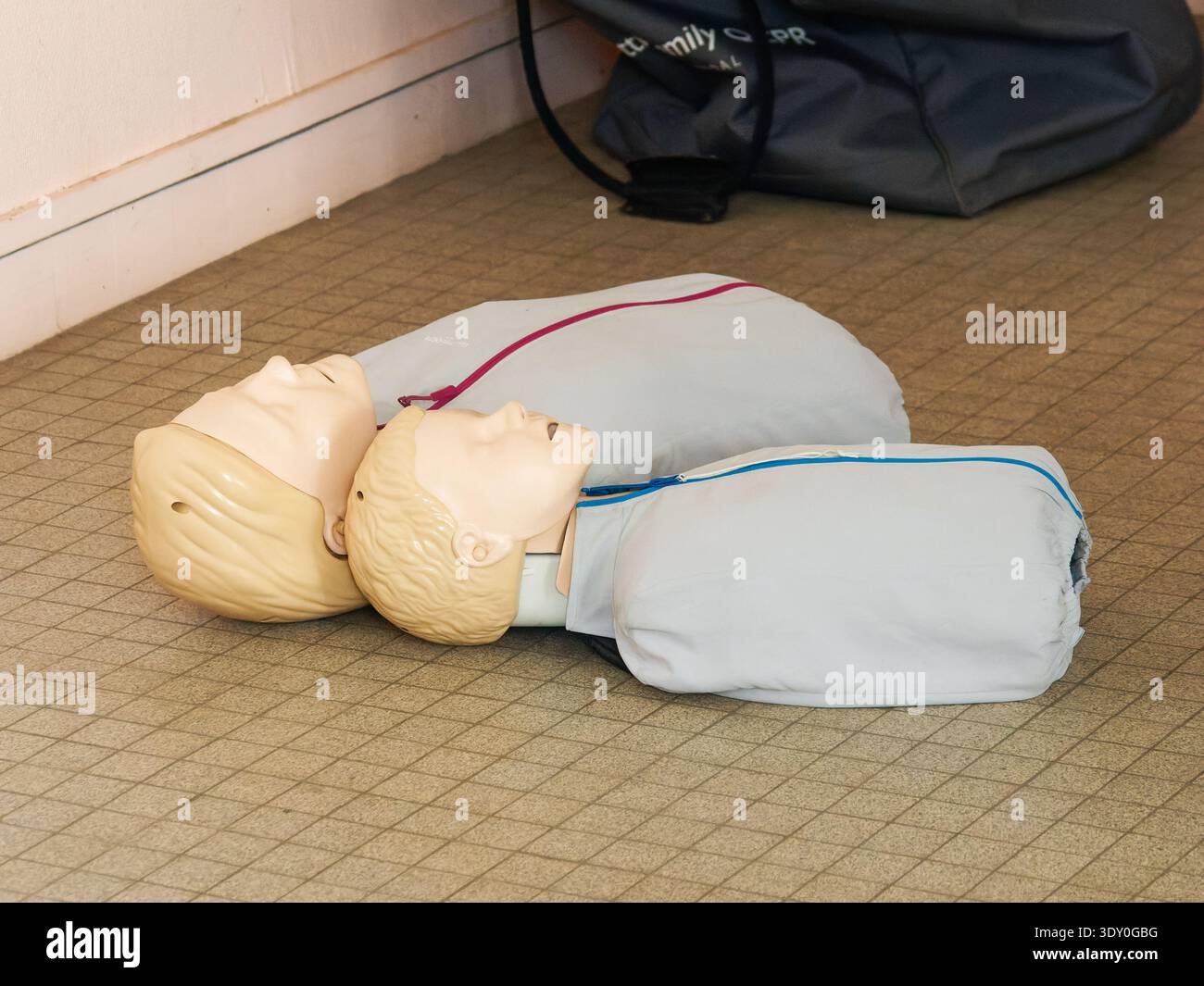 HLW-Trainingspuppen, die während eines ersten-Hilfe-Kurses auf dem Boden liegen und zur Praxis kardiopulmonaler Reanimationstechniken verwendet werden. Stockfoto