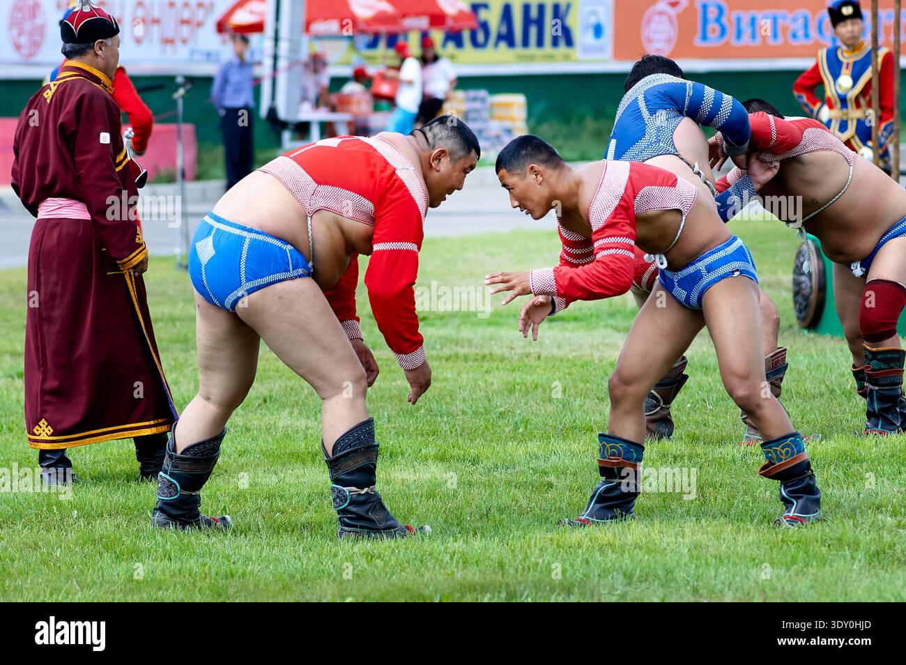 Wrestler treten beim Naadam Festival in Ulaanbaatar an und zeigen Kraft und Können, während die Zuschauer zusehen. Stockfoto