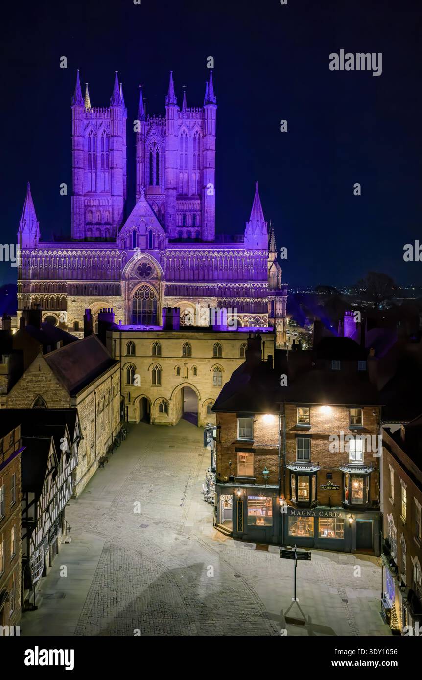 Lincoln Cathedral aus der Vogelperspektive bei Nacht, beleuchtete lila gotische Architektur, historische Wahrzeichen Skyline, Reiseziel Großbritannien, dramatische Stadtlandschaft Stockfoto