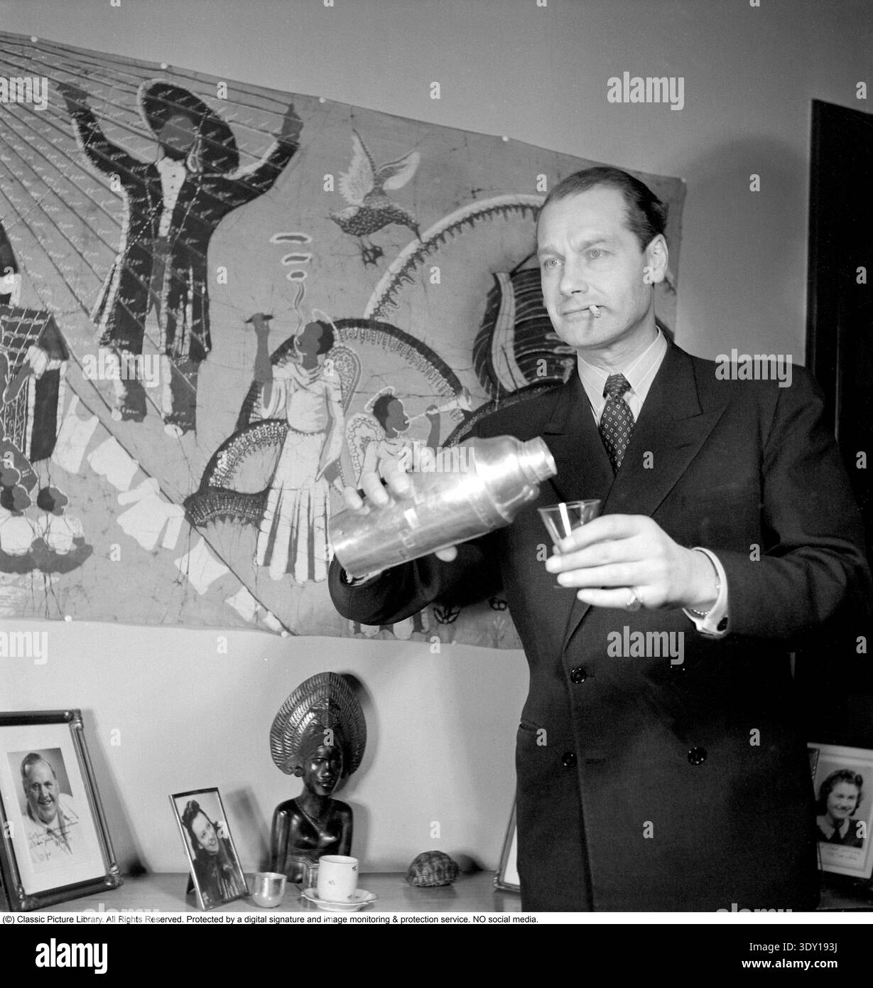 Einen Drink in den 1940ern Schauspieler Allan Bohlin (1907–1959) gießt ein Getränk aus dem Shaker in ein Glas. Zu Hause am 2. november 1948. Conard Stockfoto