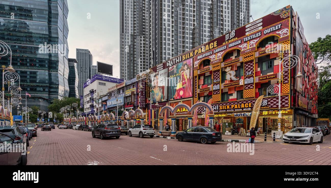 Kuala Lumpur, Malaysia - 28. Februar 2025: Lebhafte Straßenszene in Little Indua, Brickfields. Der Rathi Silk Palace und farbenfrohe indische Läden säumen die Straße und bilden einen Kontrast zu modernen Wolkenkratzern Stockfoto