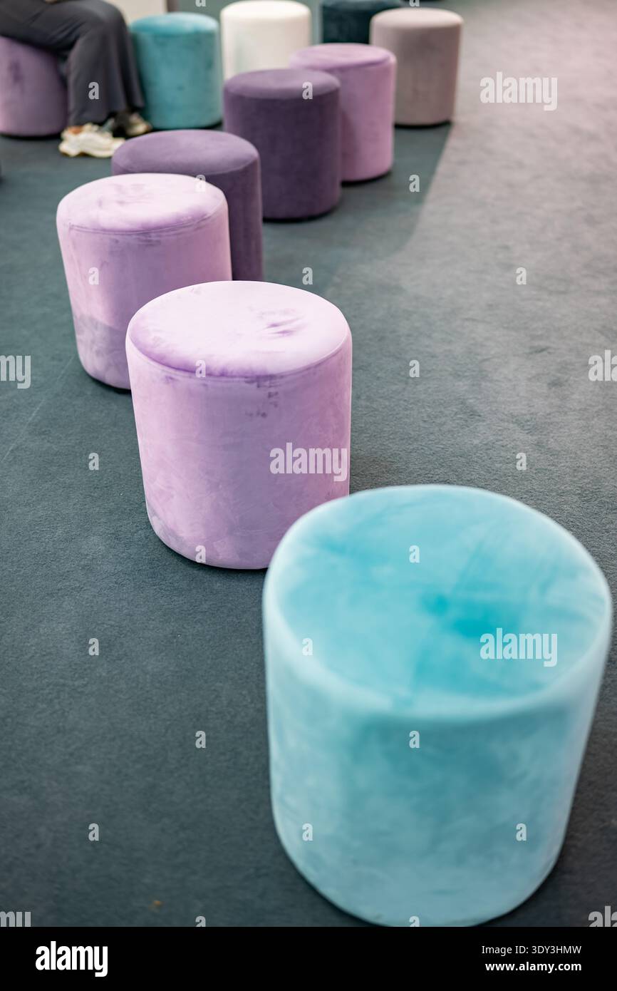 Farbenfrohe Samthocker schaffen eine legere Sitzanordnung in einem modernen Interieur Stockfoto