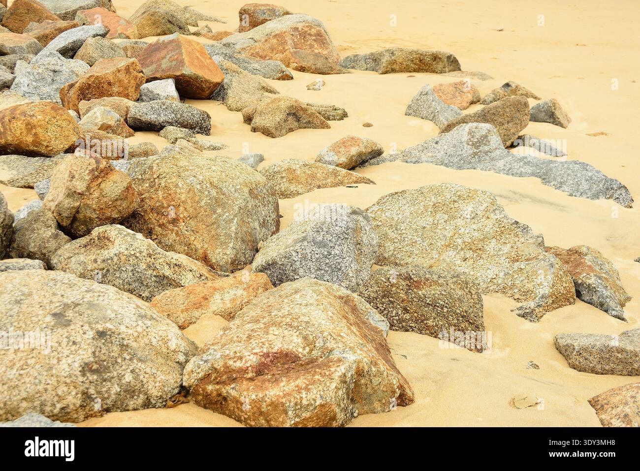Granitsteine und Sand am Meer. Nichts als Granitsteine und Sand, so weit das Auge reicht, ein einsames und lebloses Ödland. Stockfoto