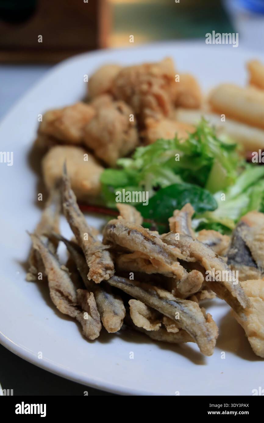 Ein Teller mit gemischten frittierten Meeresfrüchten (pescaíto frito), serviert als typisches Tapa-Gericht in einem Restaurant in Sevilla. Sevilla, Spanien Stockfoto