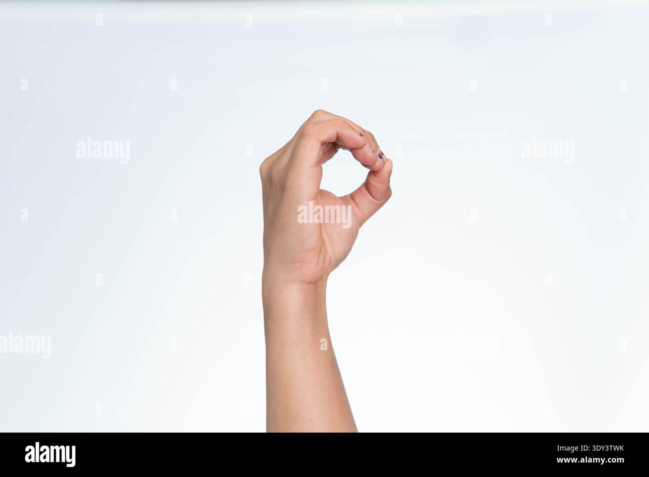 Eine Nahaufnahme der Hand einer indonesischen Frau, die mit ihren Fingern eine Kreis- oder O-Form bildet, isoliert auf einem weißen Hintergrund. Stockfoto