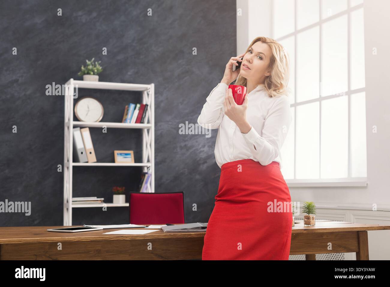 Nachdenkliche Frauenberatung per Telefon im Büro Stockfoto