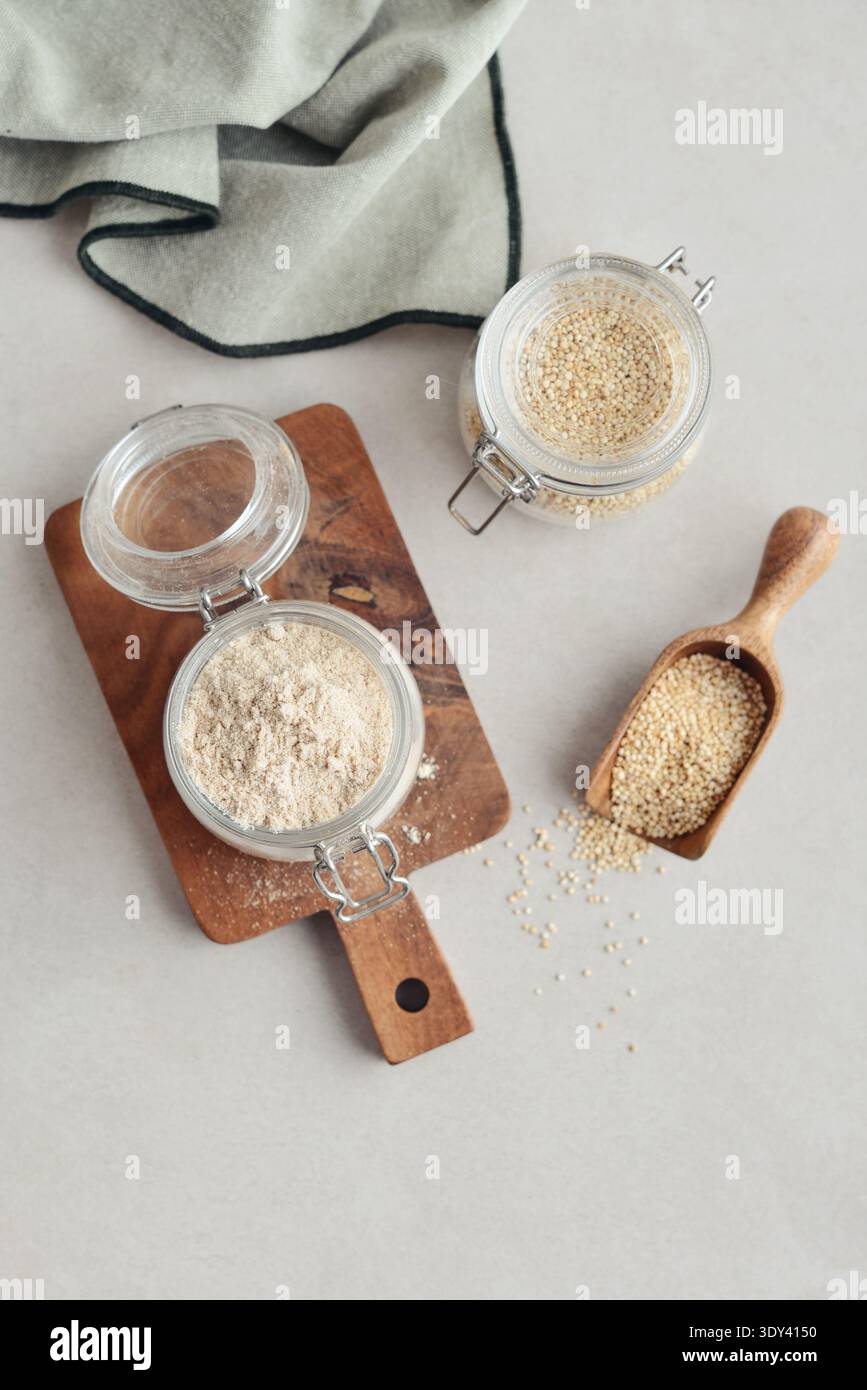 Amaranth Mehl in Glasgefäß mit roher Amaranth auf hellem Hintergrund, Draufsicht Stockfoto