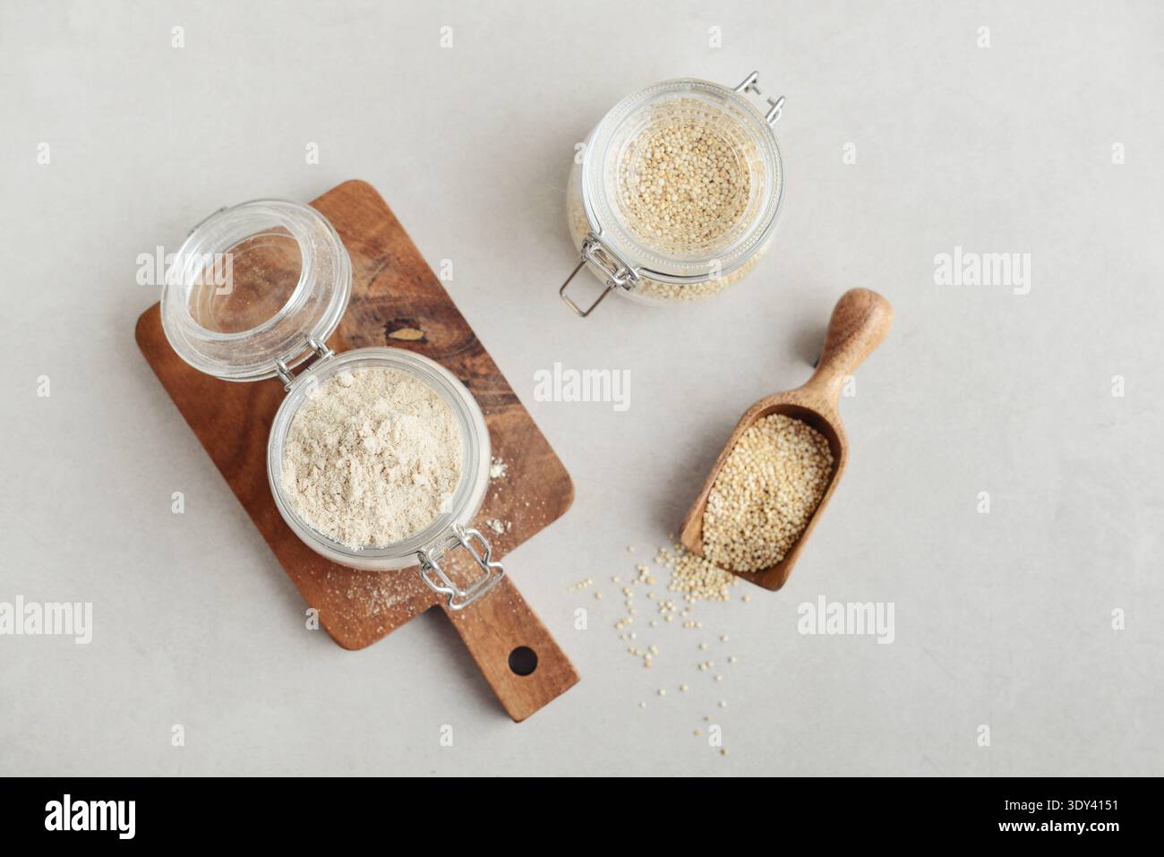 Amaranth Mehl in Glasgefäß mit roher Amaranth auf hellem Hintergrund, Draufsicht Stockfoto