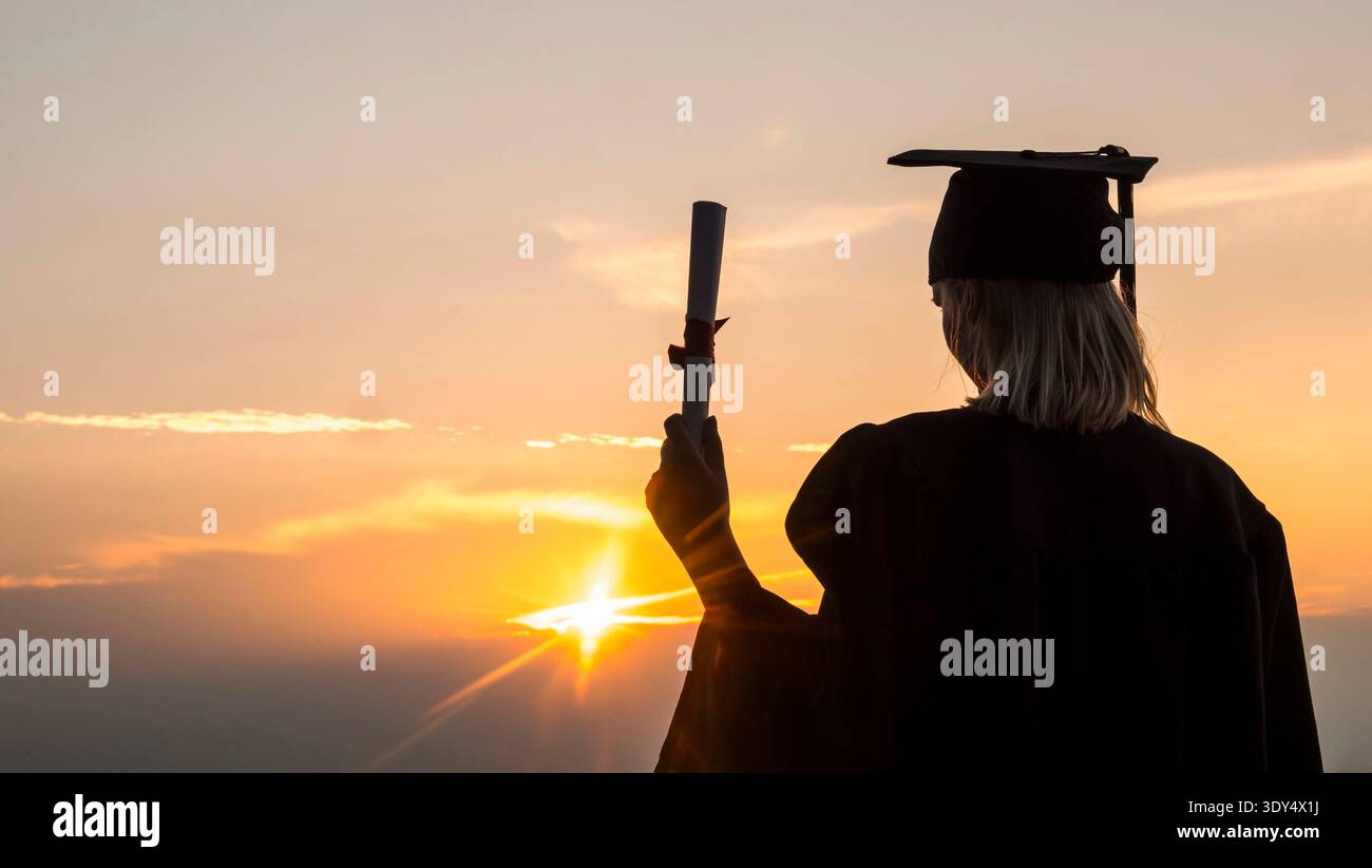 Absolvent mit Diplom steht am Strand, die Sonne beleuchtet die Hand mit einem Diplom Stockfoto