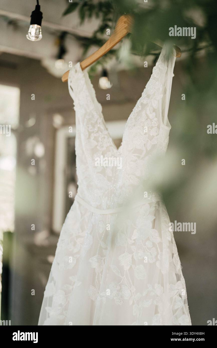 Hochzeitskleid mit Spitze hängt vor der Zeremonie am Kleiderbügel Stockfoto