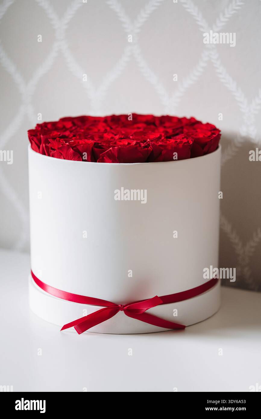 Rote Rosen in einer weißen Box mit rotem Band Stockfoto