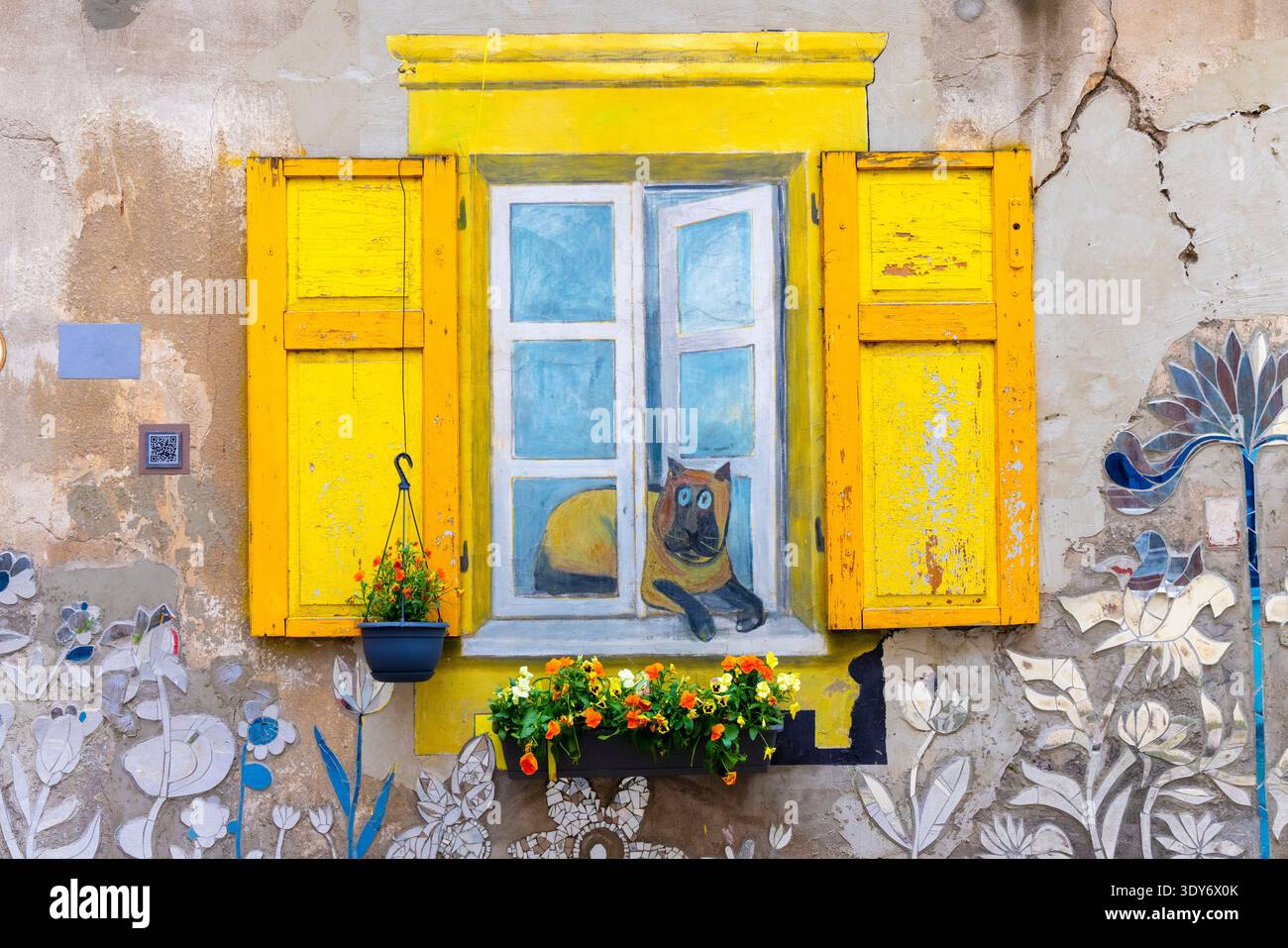 Wandgemälde an einer Wohnhofwand mit einem bemalten Fenster und einem Hund in Kaunas, Litauen Stockfoto