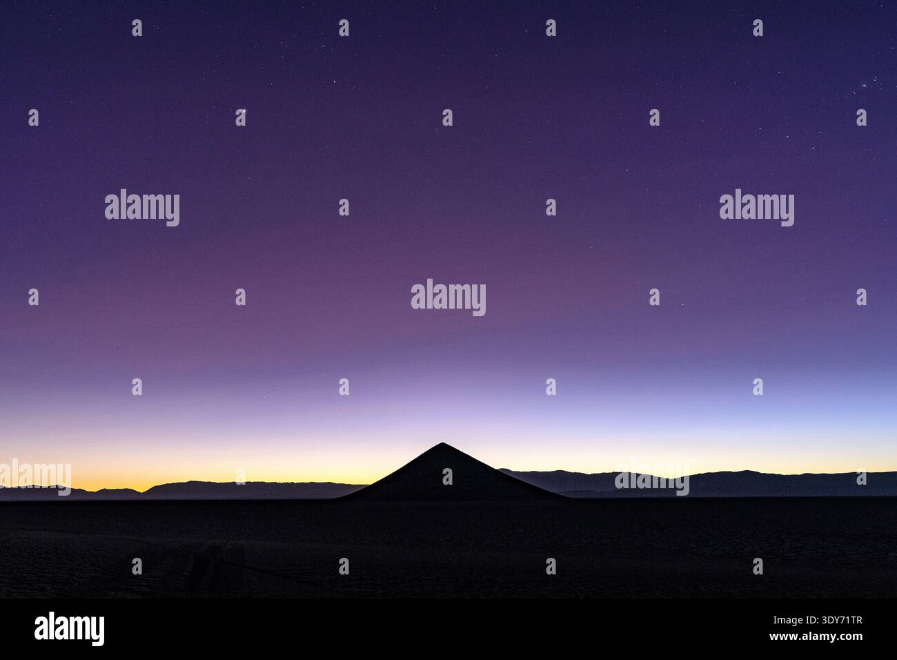 Silhouette von Cono de Arita bei Sonnenaufgang mit einem farbenfrohen Himmel in Salar de Arizaro, Salta, Argentinien Stockfoto