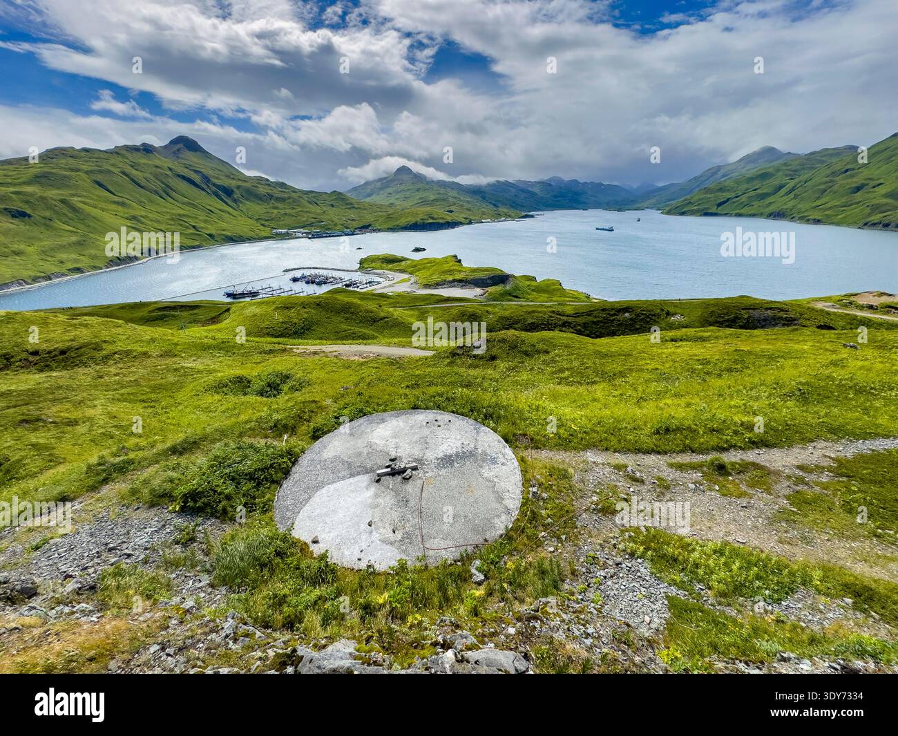 Überreste von Geschützplatzierungen aus dem Zweiten Weltkrieg in Alaska in der Nähe von Wasser und grünen Hügeln Stockfoto