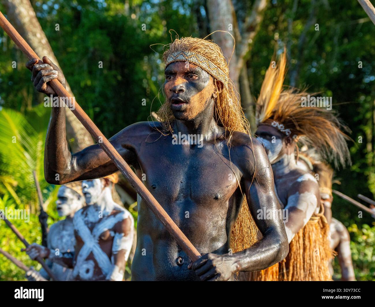 Männliche Paddler aus dem Dorf per führen eine rituelle Begrüßungszeremonie in Papua Indonesien durch, in der kulturelle Traditionen und lokale Bräuche vorgestellt werden Stockfoto
