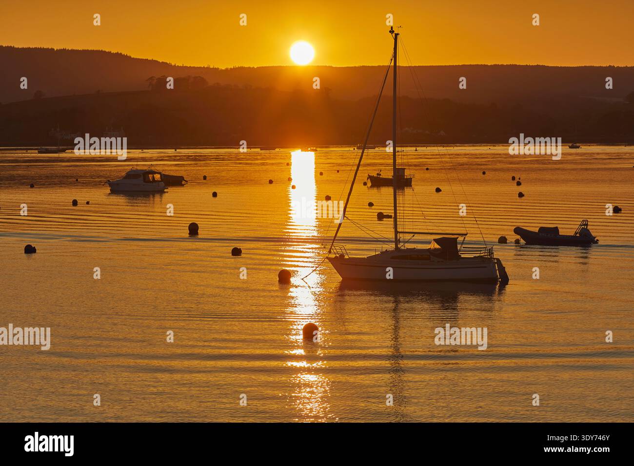 Die Sonne untergeht über der Mündung des Flusses exe, während Boote in Exmouth in Devon, Großbritannien, im Wasser schweben Stockfoto