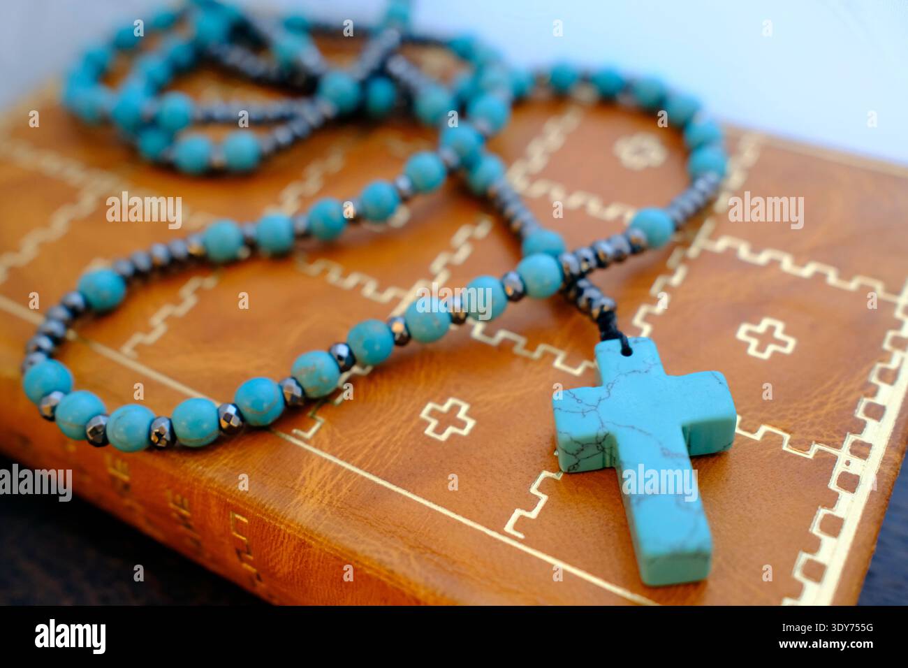 Alte heilige Bibel mit Lederbezug und Rosenkranz auf einer Ebenen Fläche, die kulturelle und religiöse Bedeutung in Warschau, Polen, zeigt Stockfoto