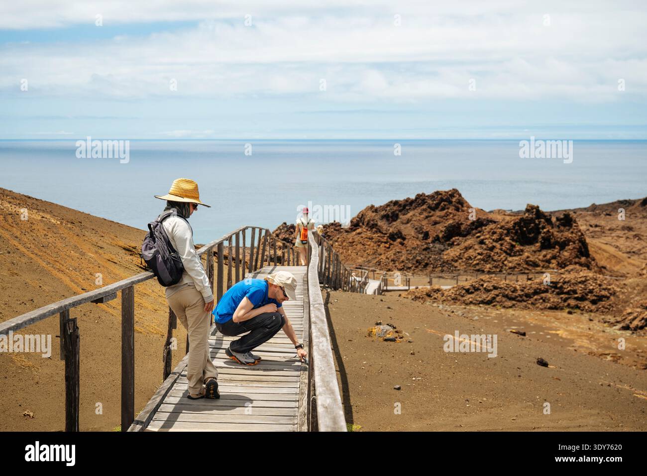 Besucher erkunden Isla Bartholom auf den Galapagos-Inseln und beobachten die lokale Tierwelt entlang des Holzpfades Stockfoto