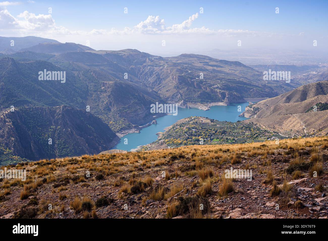 Türkisfarbener See in Guejar Sierra zwischen steilen Bergrücken in den Bergen der Sierra Nevada in Andalusien, Spanien Stockfoto