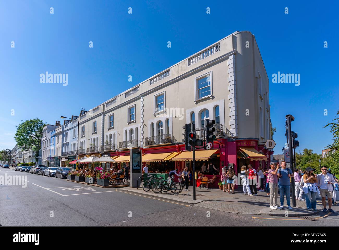 Besucher erkunden im Sommer farbenfrohe Geschäfte auf der Portobello Road in Kensington, London, und genießen die lebhafte Atmosphäre der Gegend Stockfoto