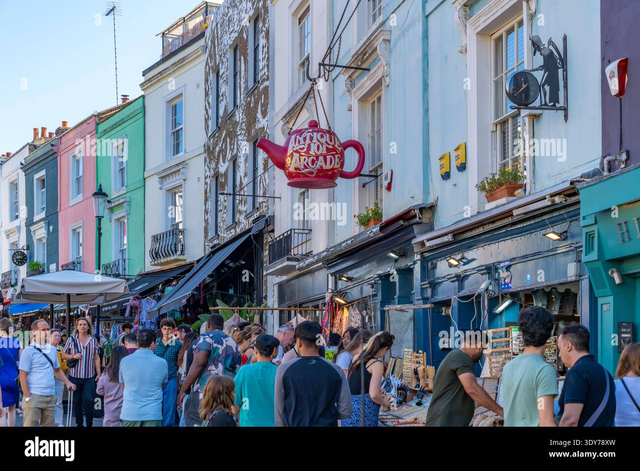 Geschäfte und Verkaufsstände ziehen viele Besucher an der Portobello Road im Sommer in Kensington, London, mit lebhaften Farben und lebhafter Atmosphäre Stockfoto