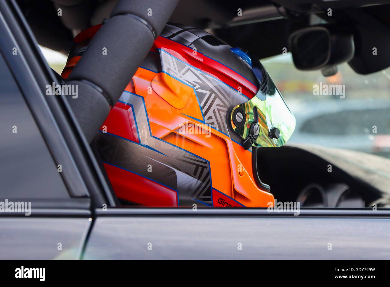 Ein professioneller Rennhelm, der von einem Passagier in einem Sportwagen getragen wird. Nürburgring. Stockfoto