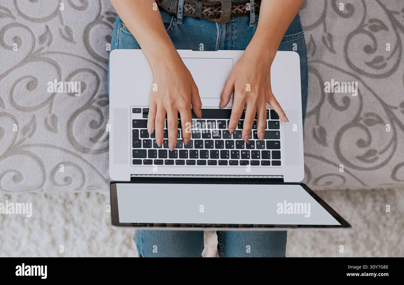 Frau, die am Laptop arbeitet und schreibt, Draufsicht Stockfoto