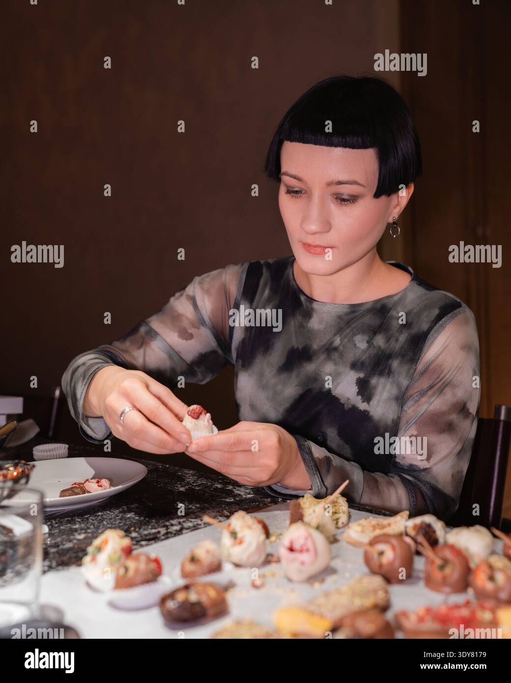 Die Teilnehmer nehmen an einem kulinarischen Meisterkurs teil, der sich mit Schokolade überzogene Erdbeeren in Tschernihiv, Ukraine, zuwendet. Die Teilnehmer bereiten Nachspeisen zu Stockfoto