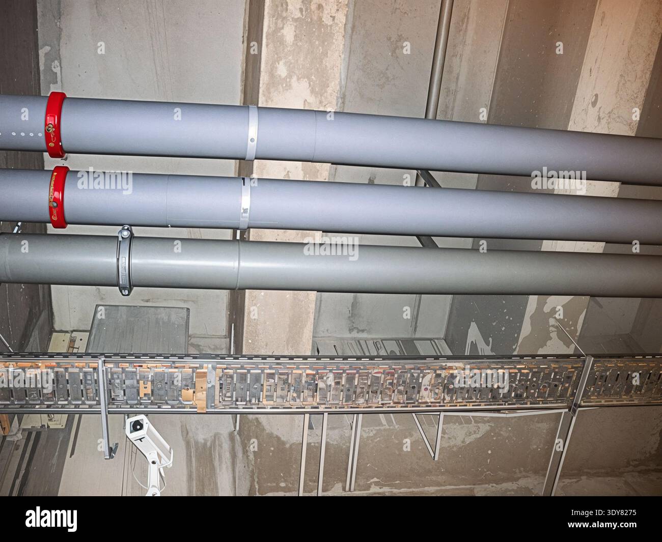 Das Bild zeigt eine Nahaufnahme von Rohren und Rohren, die an einer Decke montiert sind, und zeigt die industrielle Infrastruktur Stockfoto
