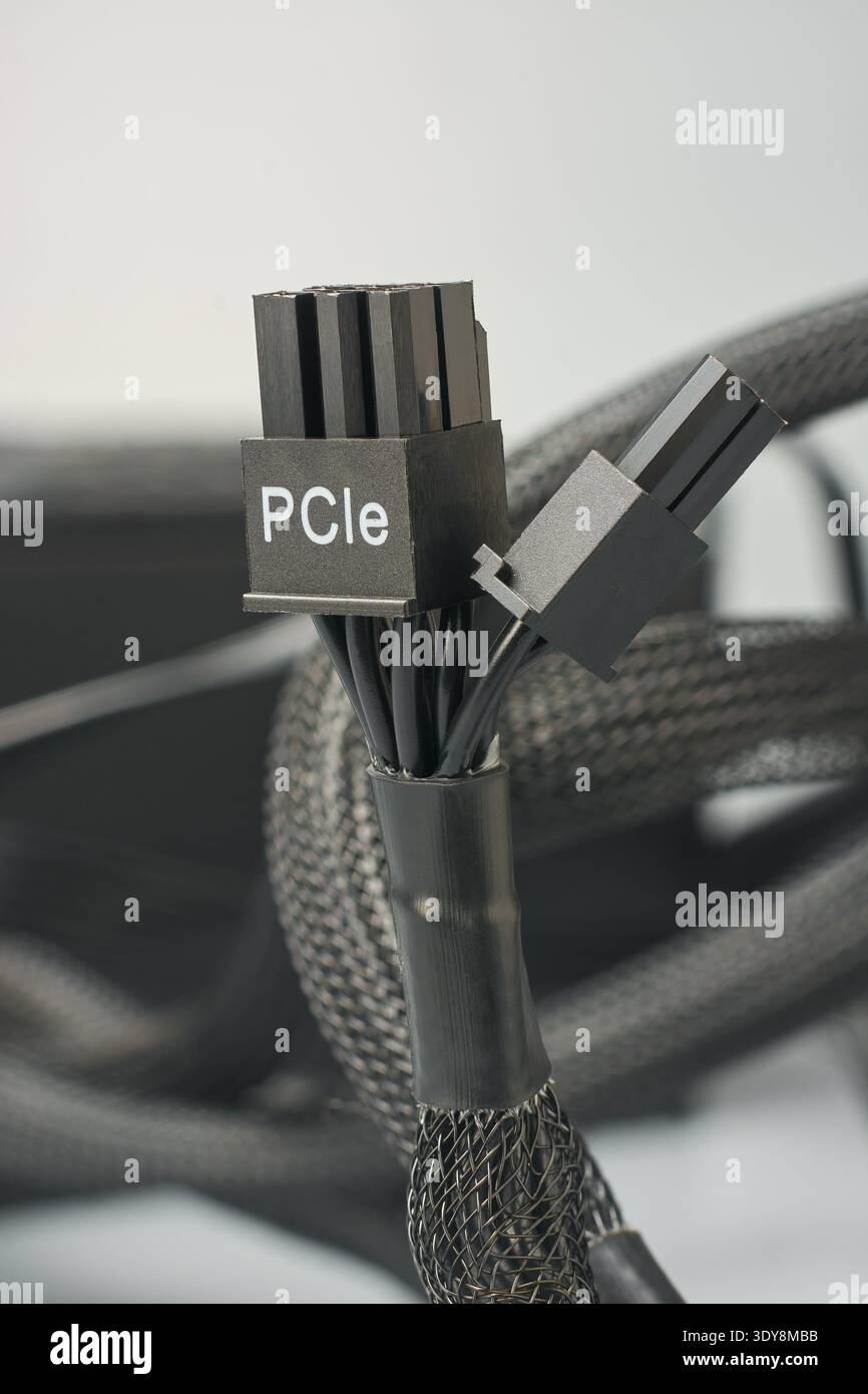 Schwarzer Kunststoff-pcie-Steckverbinder des Computernetzteils isolierter neutraler Hintergrund, gedruckter Text und gebündelte Kabel mit schwarzem Geflechtschlauch, Makroansicht Stockfoto