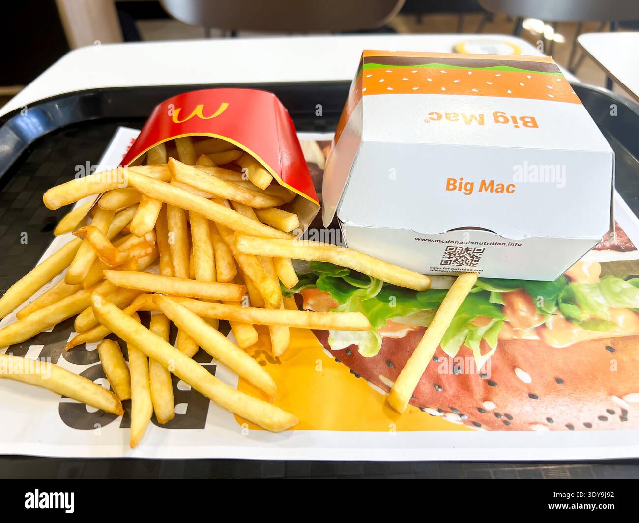 Nahaufnahme einer mittelgroßen Portion McDonalds Pommes und eines Big Mac Hamburger zum Mittagessen - Smartphone-aufgenommenes Stockfoto