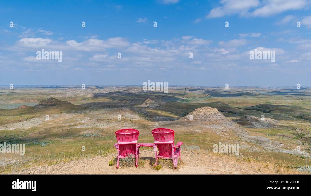Fir Mountain, SK CANADA - 6. August 2024: Die legendären roten Stühle des Parks in Kanada mit Blick auf Prärie-Badlands im Grasslands-Nationalpark. Stockfoto
