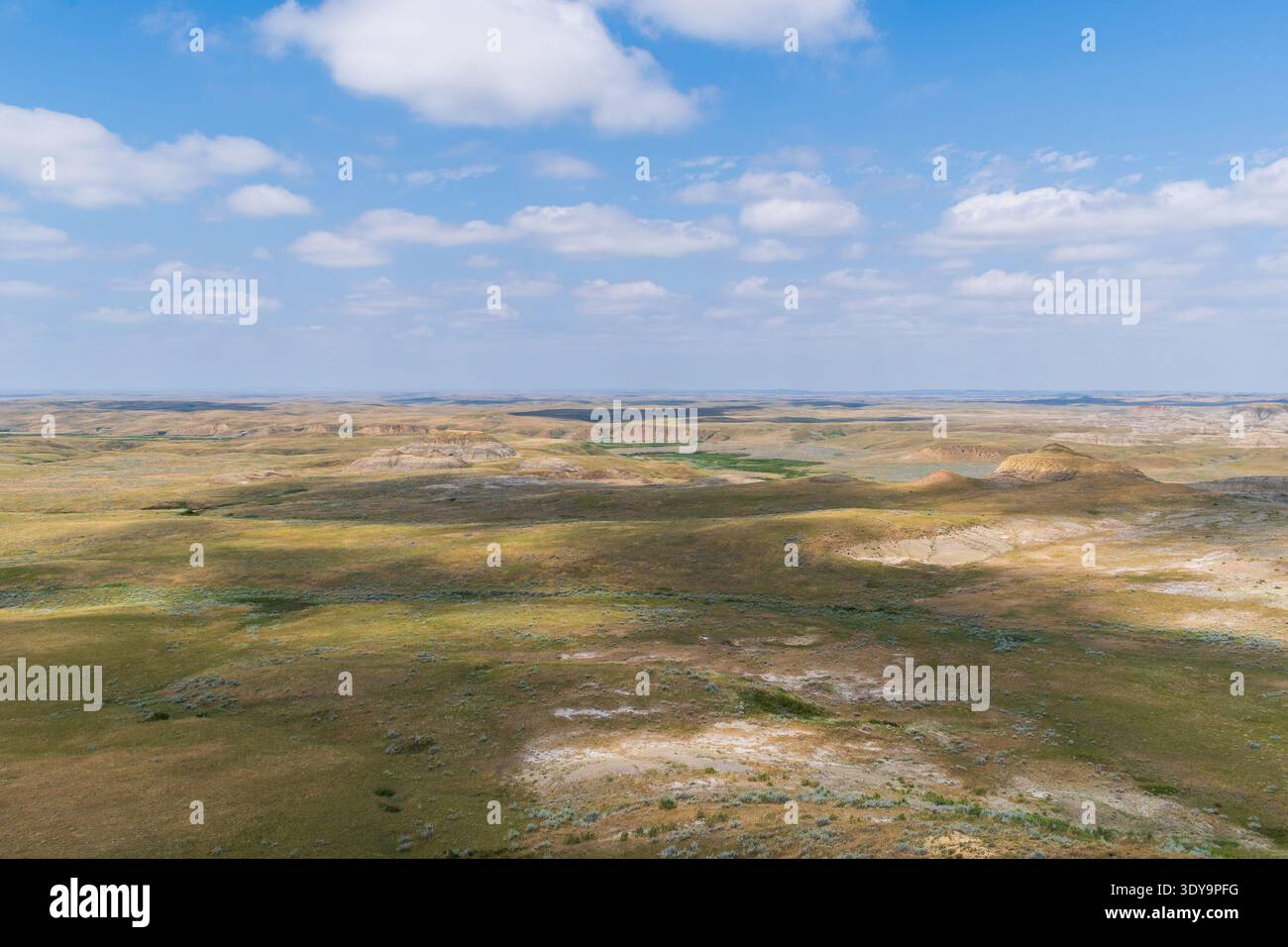 Die Badlands des Grassland-Nationalparks zeigen kühne Sedimentschichten an ihren erodierten Hängen, die durch die Klarheit des Präriehimmels hervorgehoben werden. Stockfoto