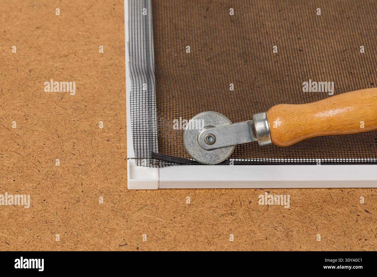 Reparieren des Fensterrahmens mit neuem Glasfasergewebe. Konzept der Heimwerkerreparatur, Wartung, Insekten- und Insektenbekämpfung Stockfoto