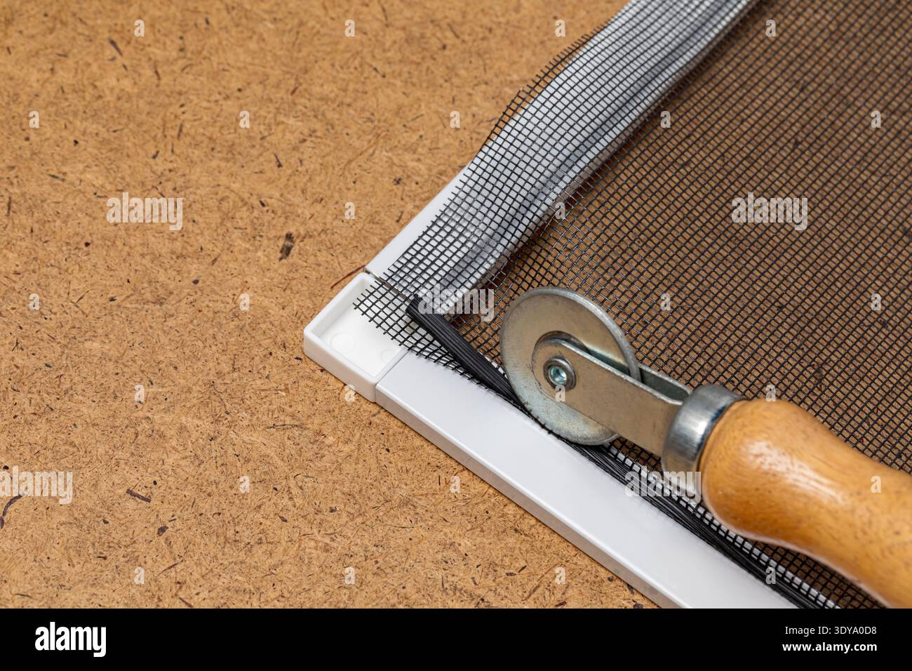 Reparieren des Fensterrahmens mit neuem Glasfasergewebe. Konzept der Heimwerkerreparatur, Wartung, Insekten- und Insektenbekämpfung Stockfoto