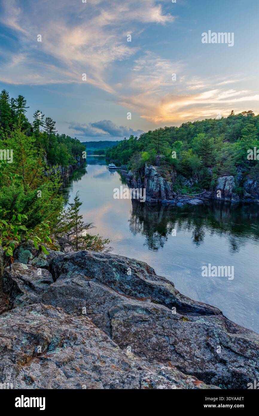 St. Croix Falls, Polk County, WI, USA – Vertikaler Blick auf den St. Croix River bei Sonnenuntergang mit einem farbenfrohen Himmel im Interstate State Park. Stockfoto