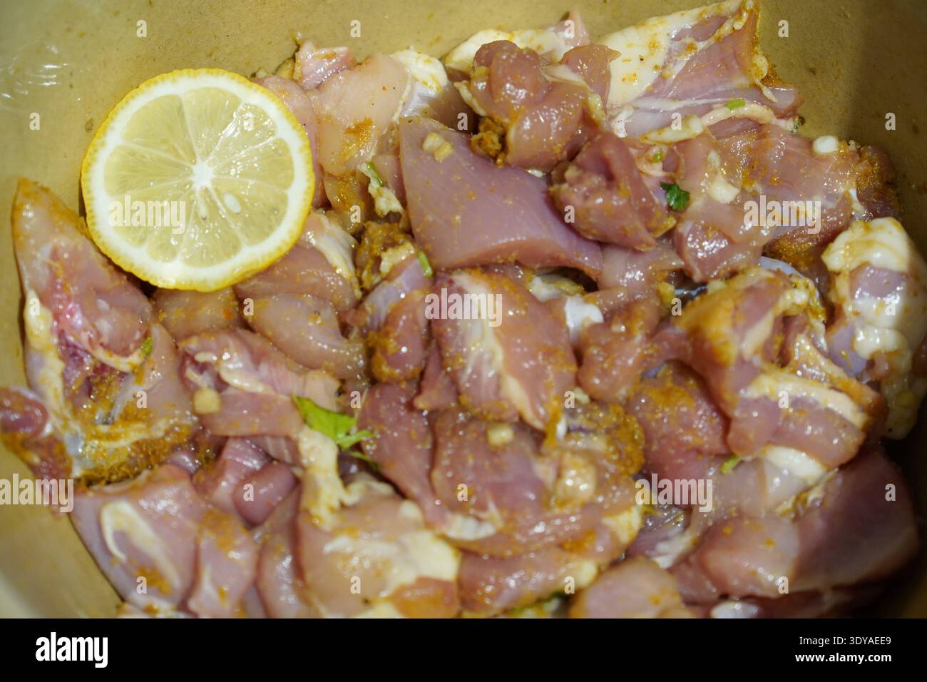 Marinierte Hähnchenschenkel in Knoblauch, Salz, Koriander und Zitrone bereit zum Kochen Stockfoto