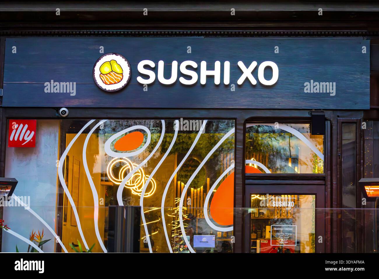 Belgrad, Serbien - Dezember 31. 2025: Sushi-Restaurantfassade in der Belgrader Straße bei Nacht mit leuchtenden LED-Lichtern. Stockfoto
