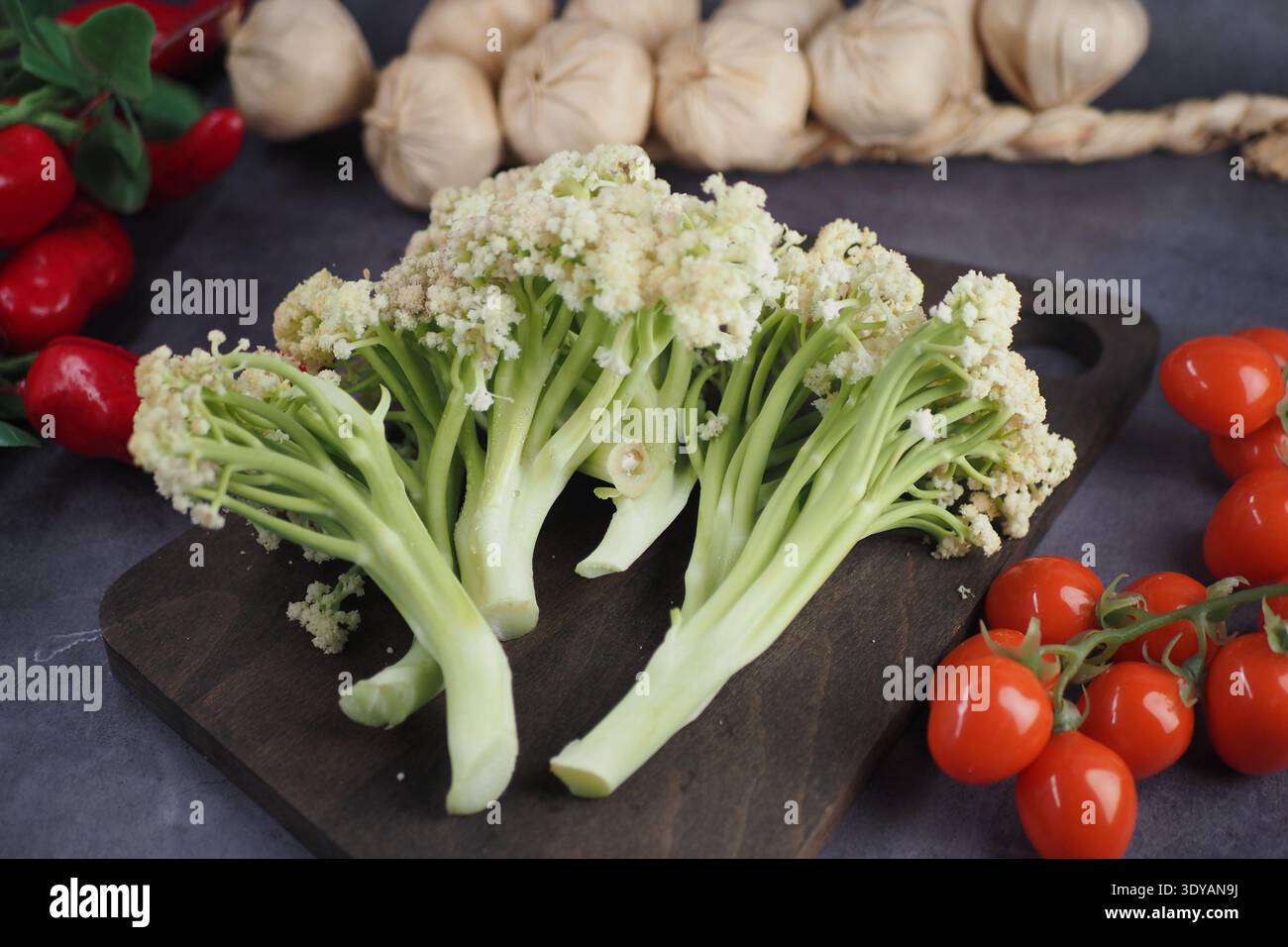 Frisches Gemüse auf einem hölzernen Schneidebrett mit Knoblauch Stockfoto