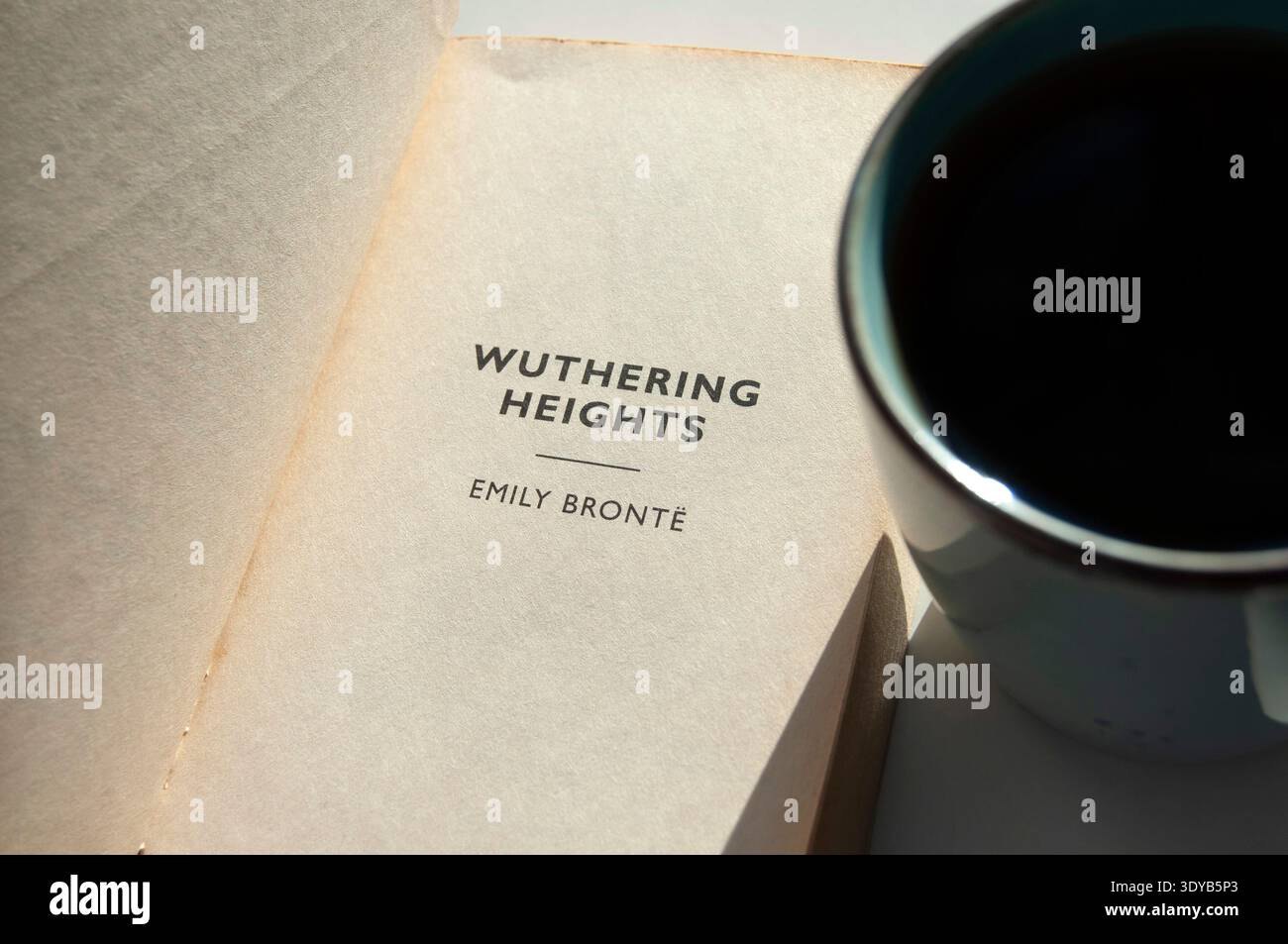 Emily Brontë Buch „Wuthering Heights“ neben einer Tasse Tee oder Kaffee. Ein offenes Retro-Buch von Bronte. Pleasure of Reading.Kiew, Ukraine - 03-07-2026. Stockfoto