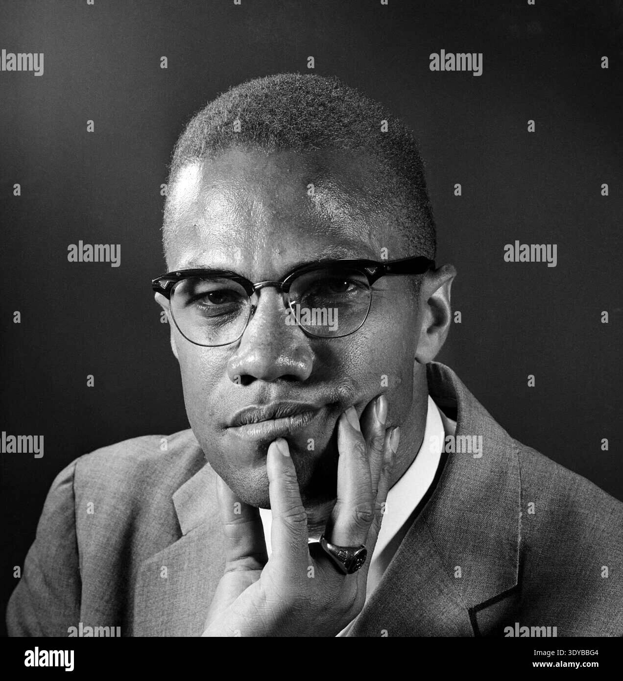Dieses legendäre Schwarz-weiß-Pressefoto von Eddie Adams aus dem Jahr 1964 zeigt den Bürgerrechtsaktivisten Malcolm X in einer nachdenklichen Pose und legt sein Kinn auf seine Hand. Sein intensiver Blick durch seine charakteristische Brille vermittelt ein Gefühl tiefer Reflexion und Entschlossenheit. Stockfoto